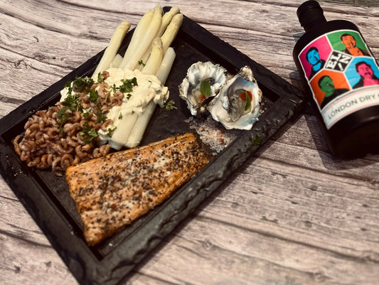 Serveerbord met warm gerookte zalm witte asperges Hollandse garnalen en oesters met gin 