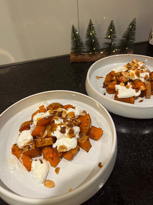 Wit serveerbord metv geroosterde pompoen, balsamico, Italiaanse kruiden, truffeloloe, burrata en geroosterde amandelschaafsel